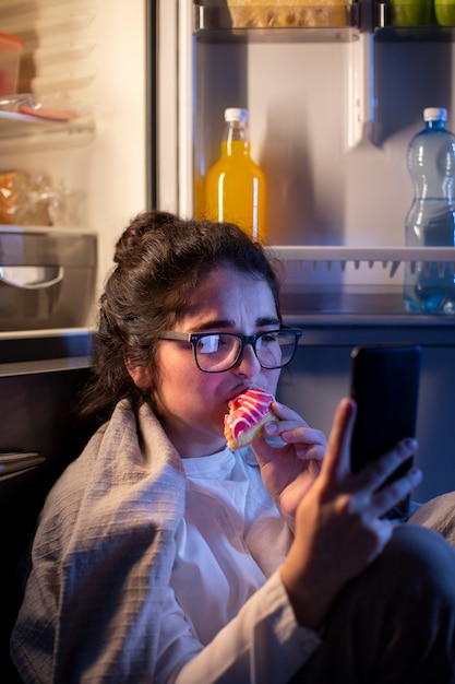 Zijaanzichtvrouw die donut eet