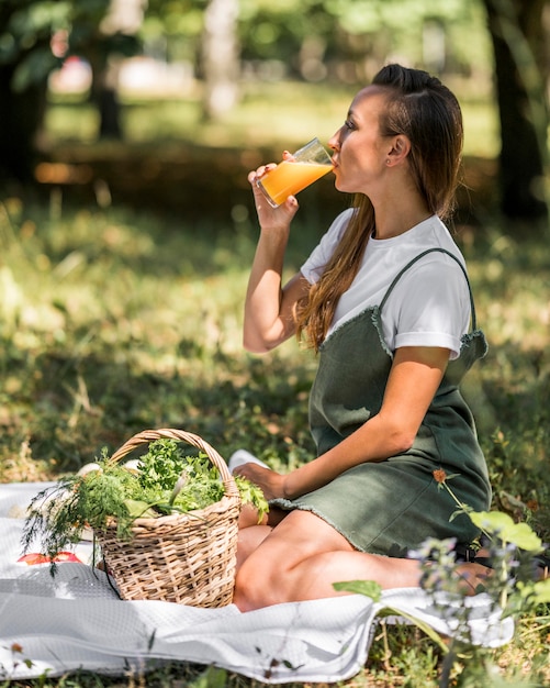 Zijaanzichtvrouw die een picknick met gezonde snacks heeft