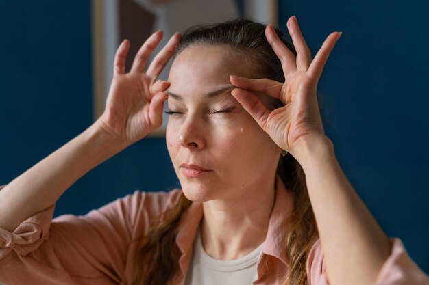 Zijaanzichtvrouw die gezichtsyoga beoefent