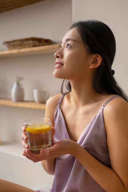 Zijaanzichtvrouw die gezonde drank houdt