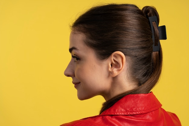 Gratis foto zijaanzichtvrouw die grote haarklem draagt