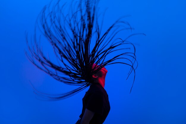 Zijaanzichtvrouw die haar haarportret beweegt