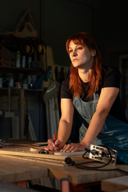 Zijaanzichtvrouw die in atelier werkt