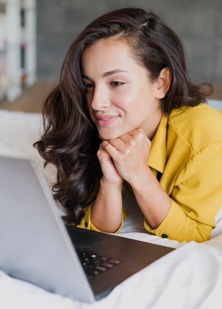 Zijaanzichtvrouw die laptop bekijkt