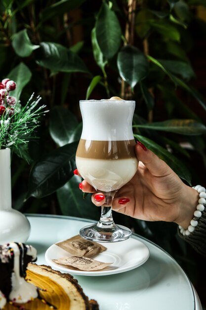 Zijaanzichtvrouw die latte drinken