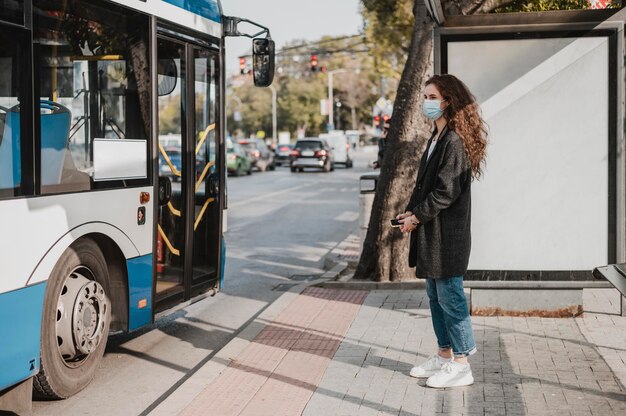 Zijaanzichtvrouw die op de bus wacht