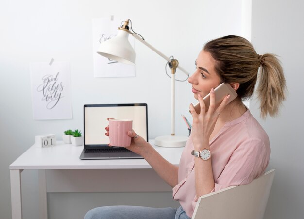 Zijaanzichtvrouw die over telefoon spreekt