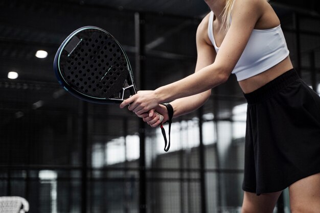 Zijaanzichtvrouw die paddletennis speelt