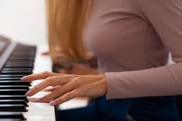 Gratis foto zijaanzichtvrouw die piano speelt