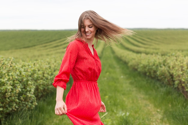 Gratis foto zijaanzichtvrouw die rode kleding draagt