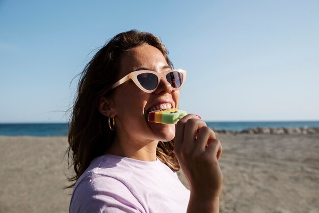 Zijaanzichtvrouw die roomijs eet