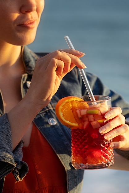 Gratis foto zijaanzichtvrouw die sangria drinkt