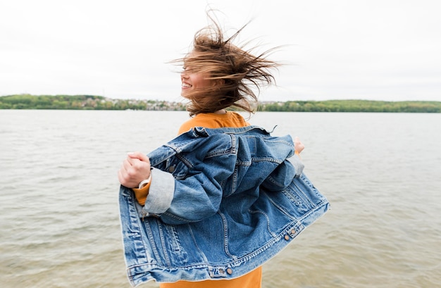 Gratis foto zijaanzichtvrouw die van zeebries genieten