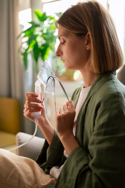 Gratis foto zijaanzichtvrouw die vernevelaar gebruikt