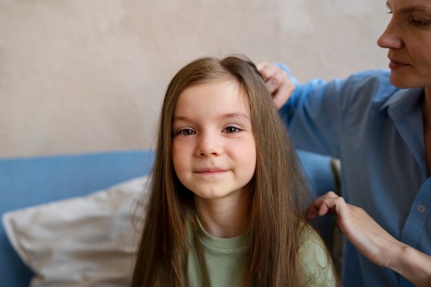 Zijaanzichtvrouw die voor meisje zorgt