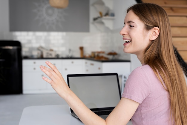 Zijaanzichtvrouw die weg met laptop model kijken