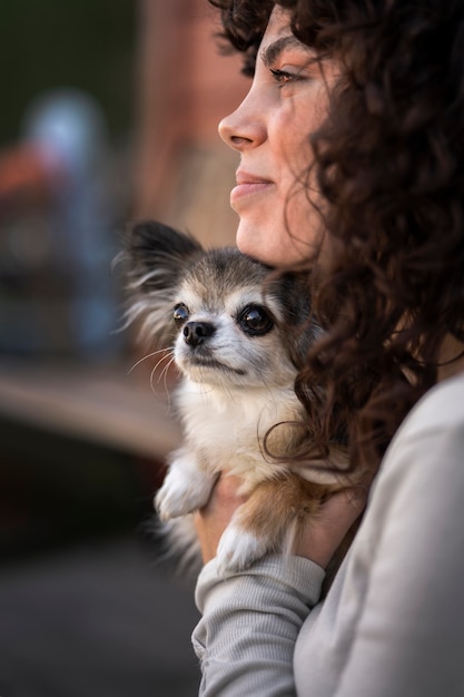 Gratis foto zijaanzichtvrouw met leuke chihuahuahond