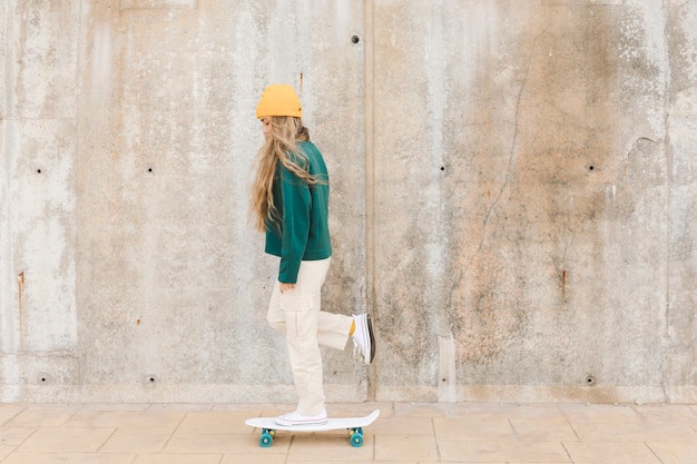 Zijaanzichtvrouw met skate openlucht