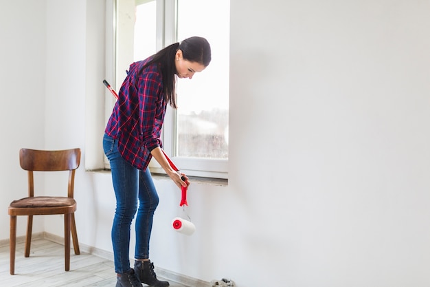 Gratis foto zijaanzichtvrouw met verfrollen