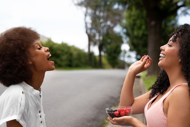 Gratis foto zijaanzichtvrouwen die bessen eten