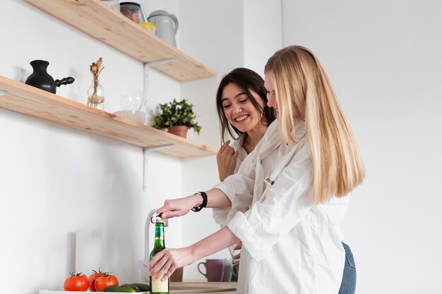 Zijaanzichtvrouwen die bier hebben bij lunch