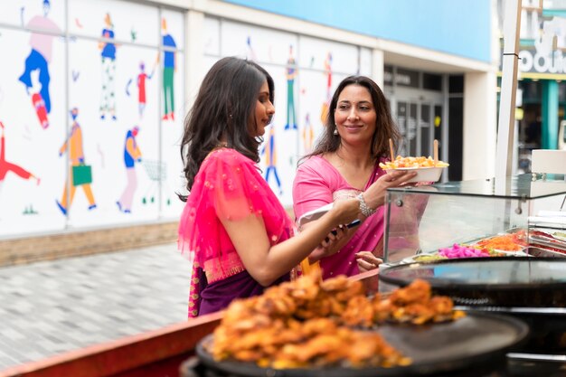 Zijaanzichtvrouwen die eten kopen