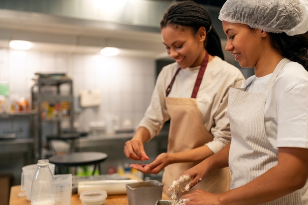 Zijaanzichtvrouwen die in keuken werken