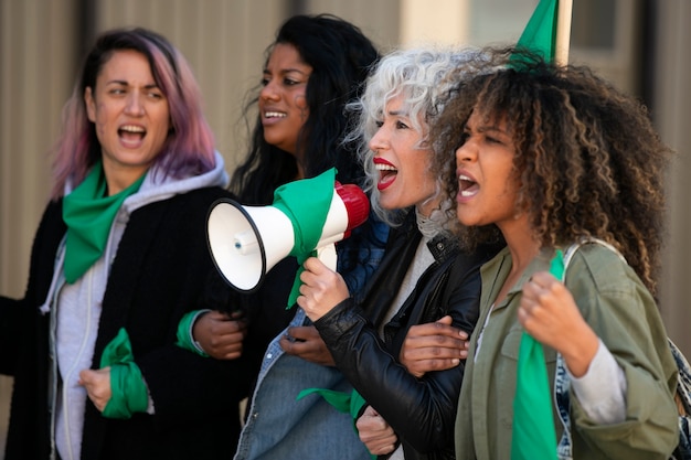 Zijaanzichtvrouwen die in openlucht protesteren