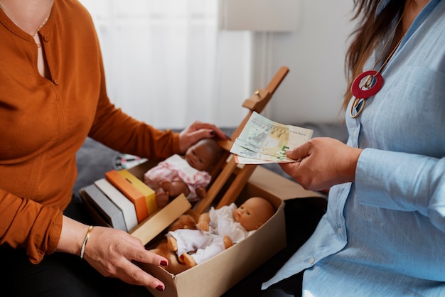 Gratis foto zijaanzichtvrouwen die items uitwisselen