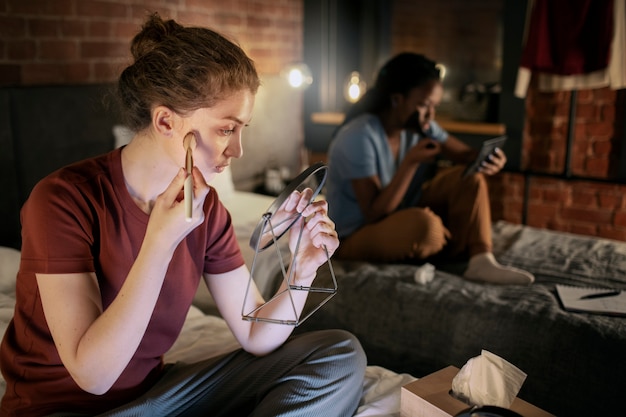 Zijaanzichtvrouwen die make-up opdoen