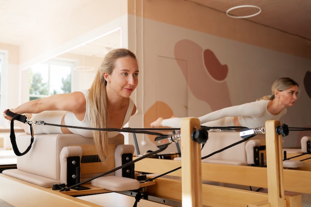 Gratis foto zijaanzichtvrouwen die samen pilates doen