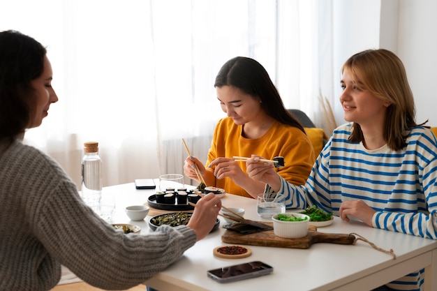 Gratis foto zijaanzichtvrouwen die thuis eten