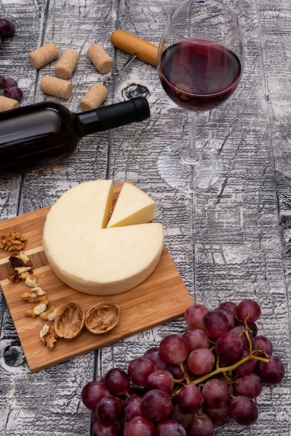 Zijaanzichtwijn met druif en kaas en op witte houten verticaal
