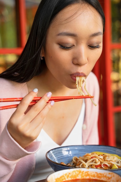 Zijdebeeld vrouw die smakelijke noedels eet