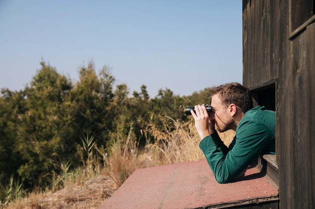 Gratis foto zijdelings man vogels kijken