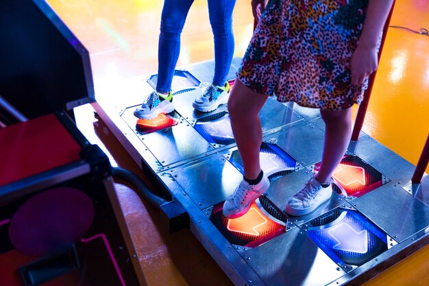 Zijdelings vrouwen die dansende arcade spelen