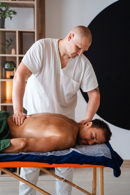 Gratis foto zijkant zicht man die een professionele massage krijgt