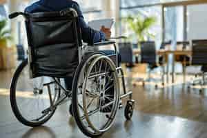 Gratis foto zijkant zicht man in rolstoel aan het werk