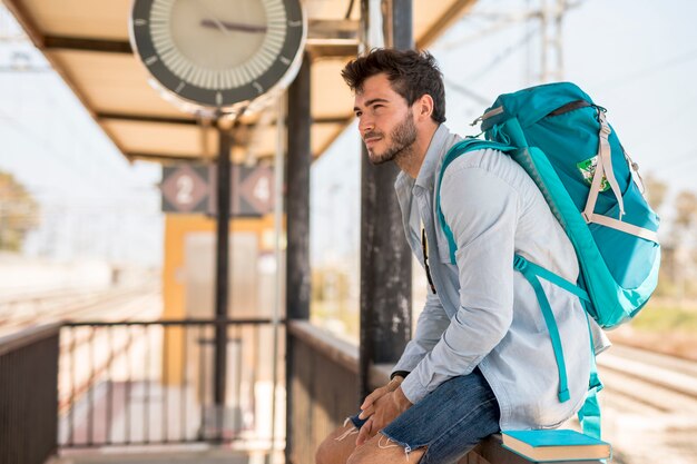 Zijwaarts reiziger die op trein wacht