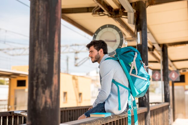 Zijwaarts reiziger die op trein wacht