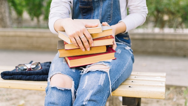 Gratis foto zittende persoon met boeken stapel