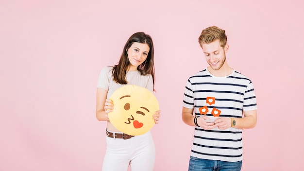 Zoals pictogrammen over man met behulp van mobiele telefoon naast vrouw met kus emoji