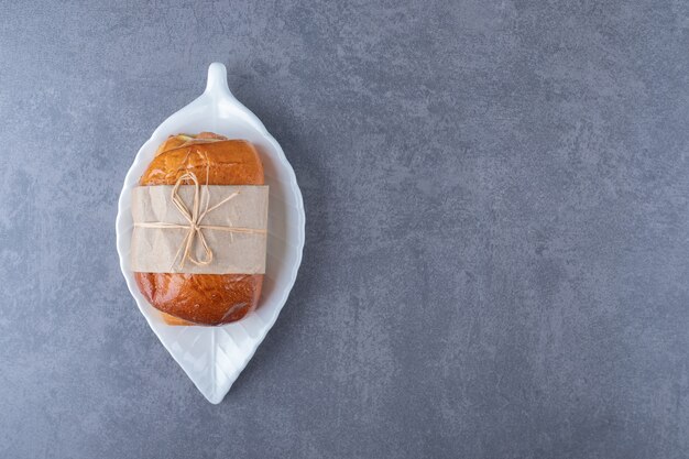 Zoet brood op een schotel op marmeren tafel.