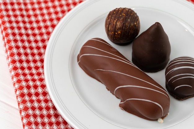 Gratis foto zoete chocolade snoepjes op witte plaat close-up