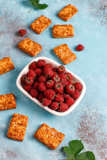 Zoete heerlijke frambozenjamkoekjes met rijpe frambozen, bovenaanzicht