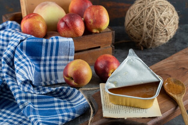 Zoete jam met perziken en houten lepel op een houten bord