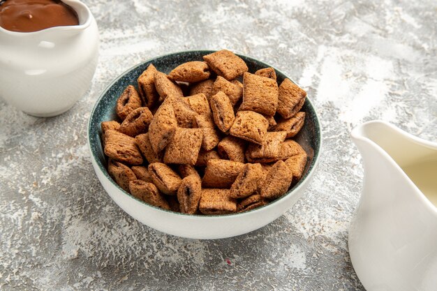 Gratis foto zoete kussenkoekjes met chocosaus op wit