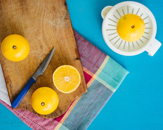 Gratis foto zoete limoenen en handmatige juicer op blauwe achtergrond