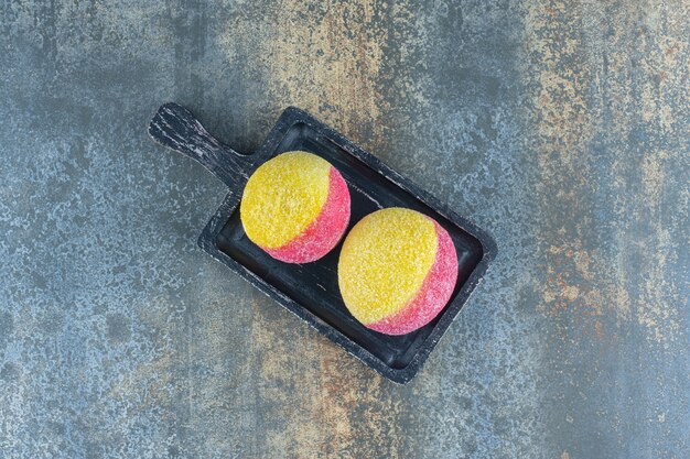Zoete perzikvormige zelfgemaakte koekjes op het houten bord, op het marmeren oppervlak.