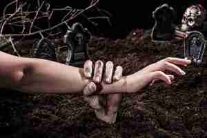 Gratis foto zombie hand met persoon arm op halloween kerkhof